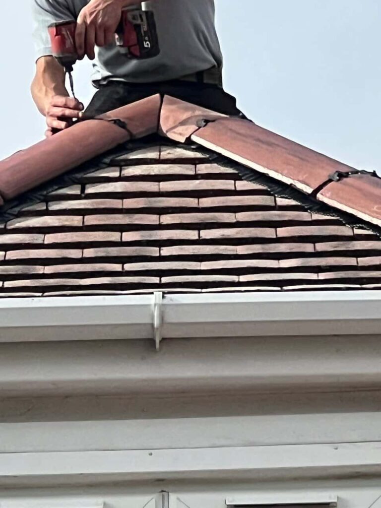 This is a photo of one of the operatives of TRP Roofing Pocklington installing new ridge tiles